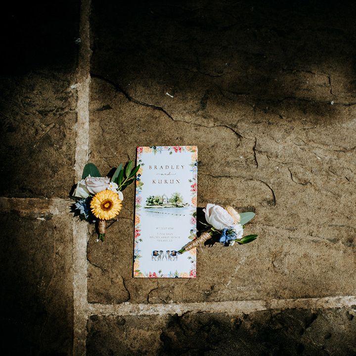 Colourful wedding stationery complete with floral illustrations beside flowers 