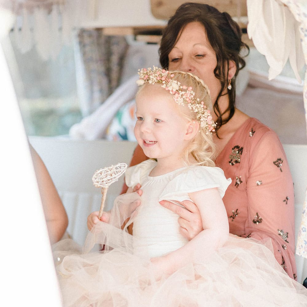 Flower girl wears pastel peach tutu and baby's breath flower crown