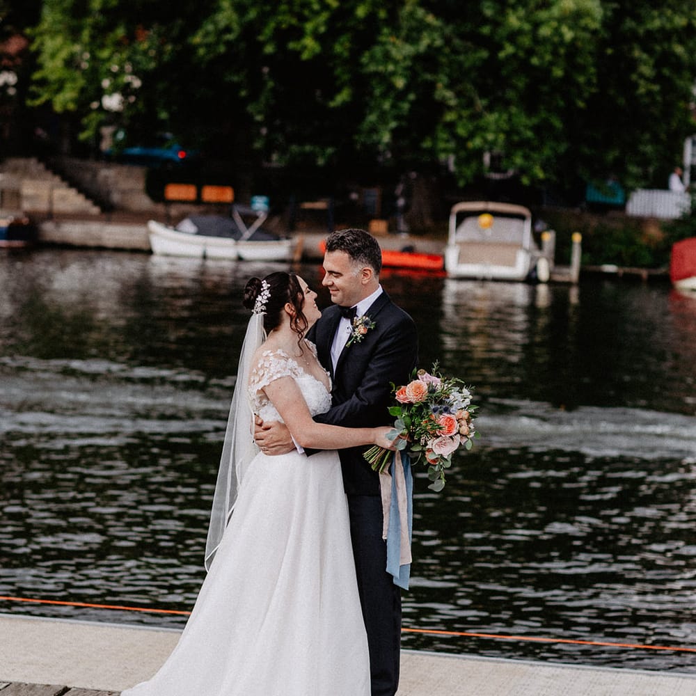 The bride and groom stare into each other's eyes and smile at each other for their traditional wedding 