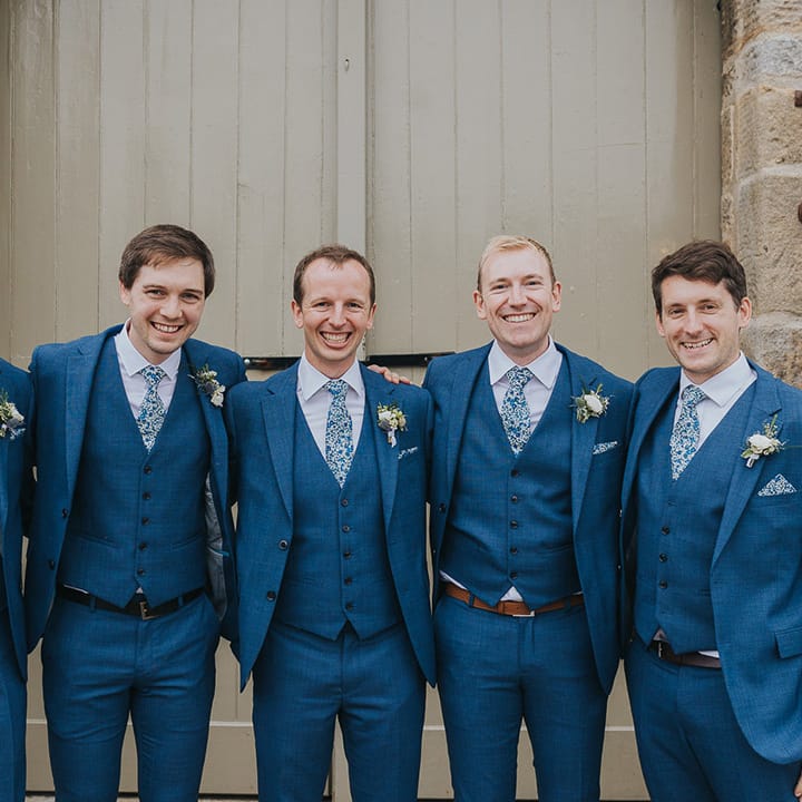 Groomsmen in Navy blue three piece suits with floral ties 