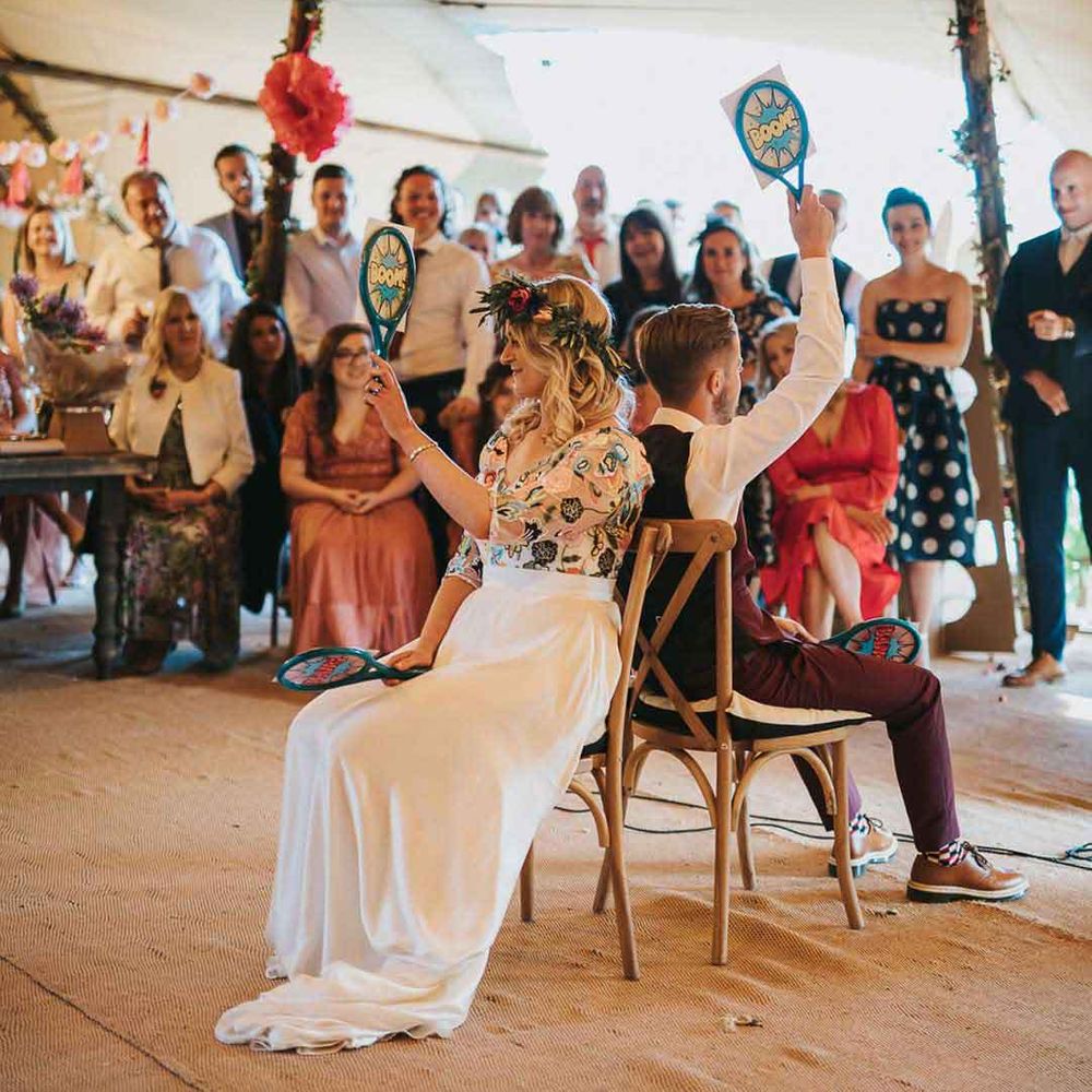 Bride in ethereal boho wedding dress and groom in waistcoat playing Mr and Mrs wedding game 