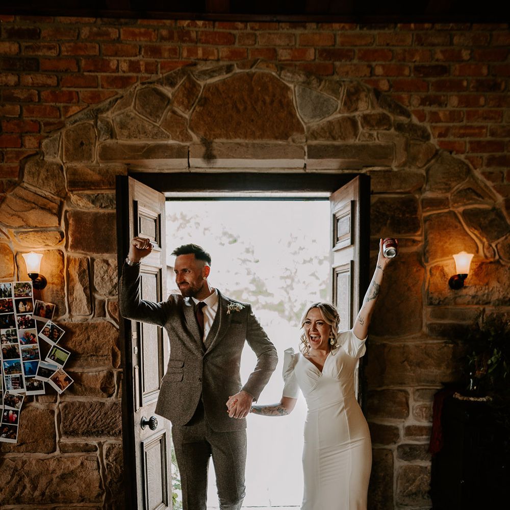 The bride and groom enter their wedding reception excitedly 
