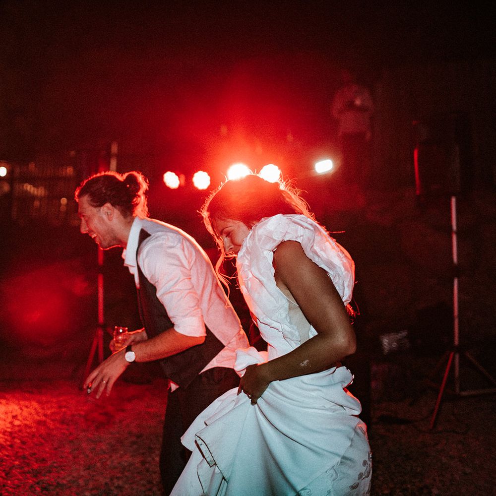 Bride and groom dancing on the beach with bride in a ruffle sleeve wedding dress