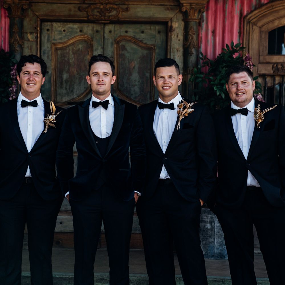 Groom and groomsmen in matching tuxedo suits for destination wedding in South Africa