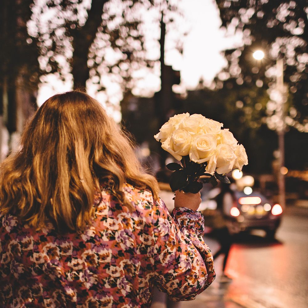 Bride holds up white rose bouquet as she walks through Chelsea