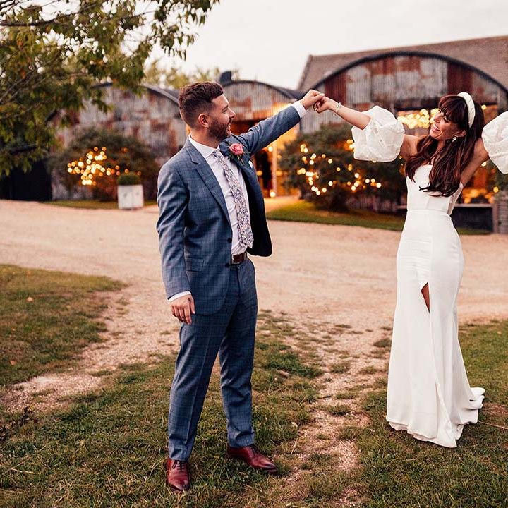 Bride & groom celebrate outdoors on their wedding day after Cotswolds wedding ceremony