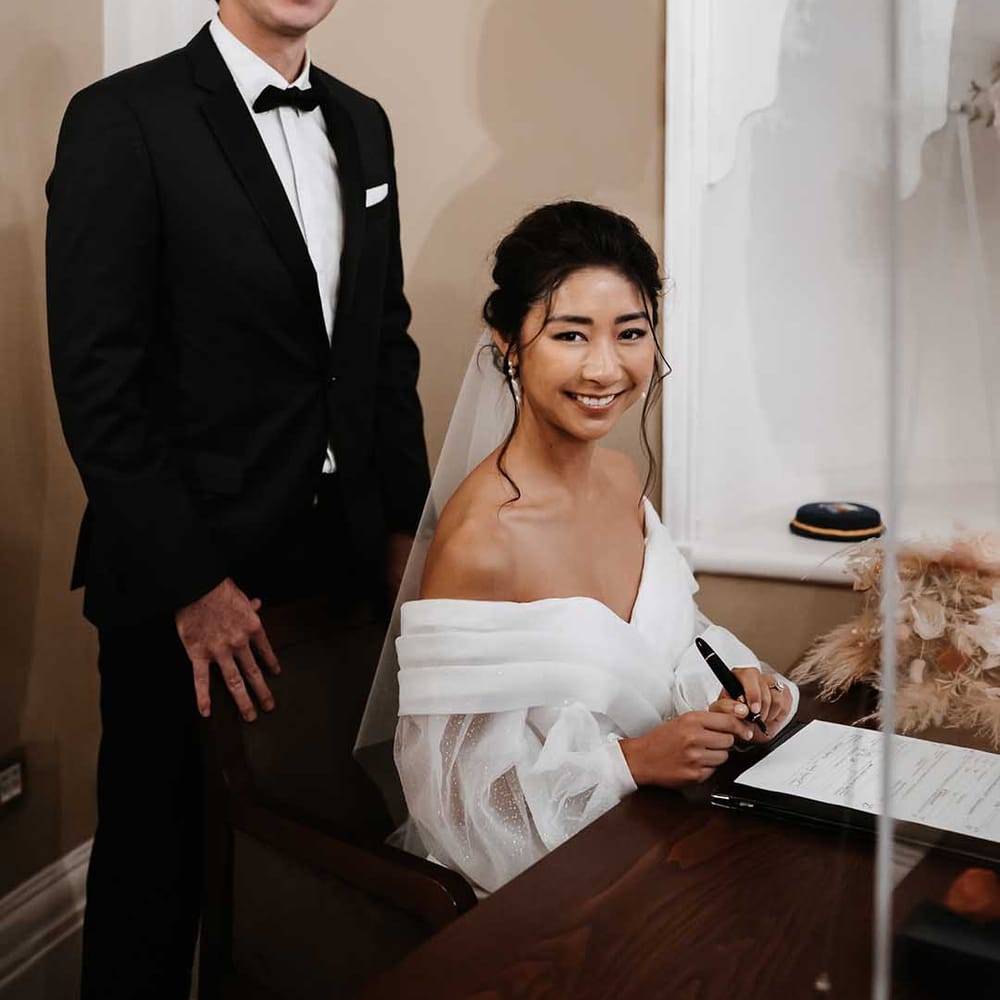 Groom in dark suit with Bride who' sleeves twinkle 