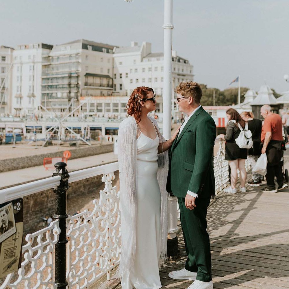 Bride & groom stand with one another near the beachfront of Brighton on their wedding day