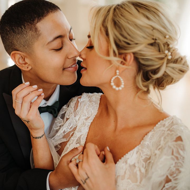 Intimate wedding photograph of an LGBTQI+ couple kissing in a tuxedo, bow tie and lace wedding dress 