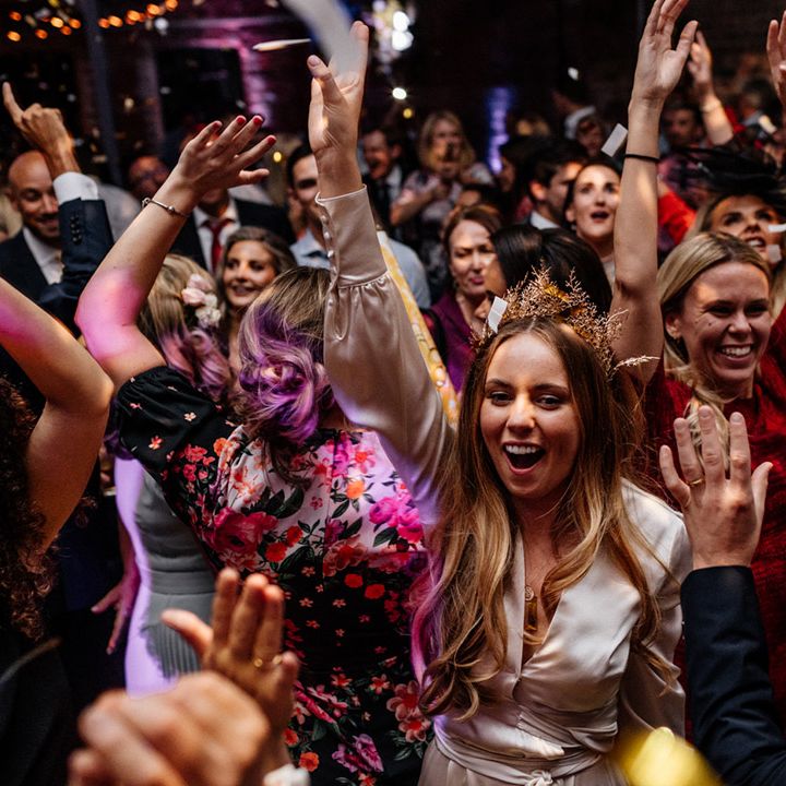 Bride on the dance floor in a satin wrap wedding dress with gold crown 