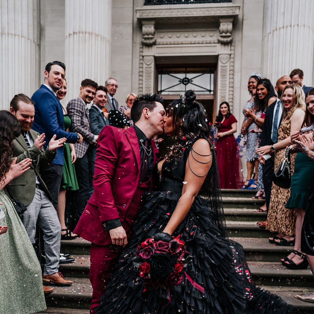Bride & groom kiss at the end of Old Marylebone Town Hall steps after wedding ceremony 