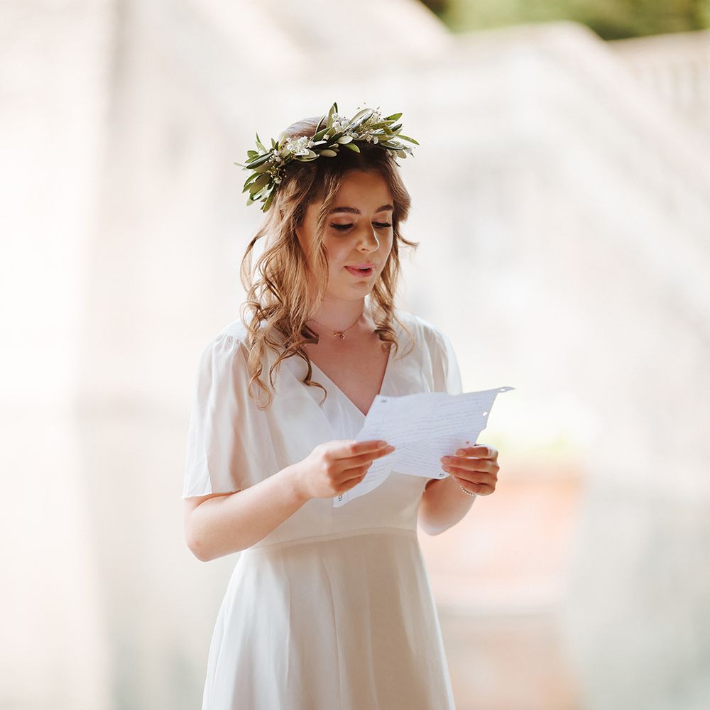 Girl in a flower crown reads a wedding reading for an informal role in a wedding 