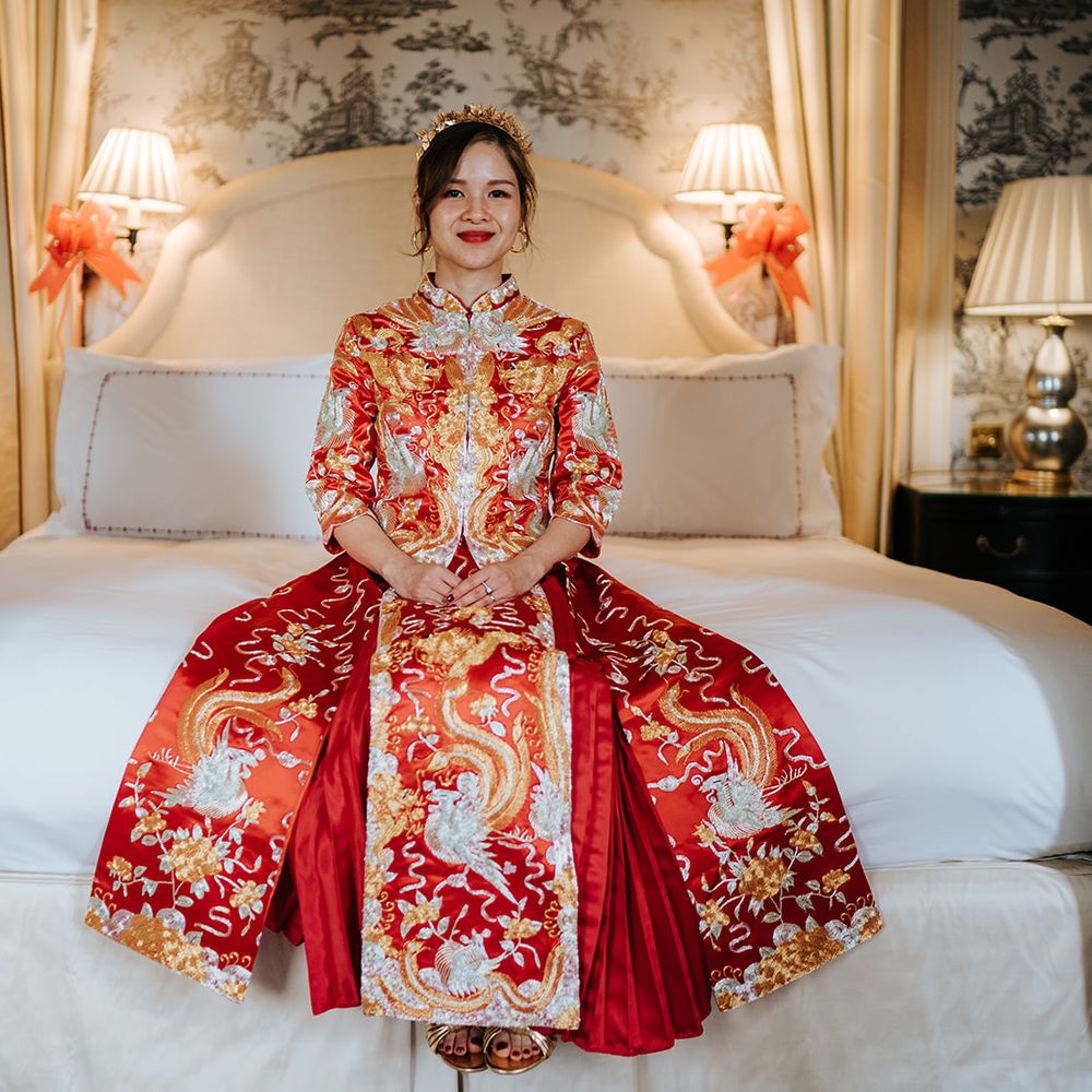 East Asian bride wears beautifully embroidered wedding dress with red and gold colouring 