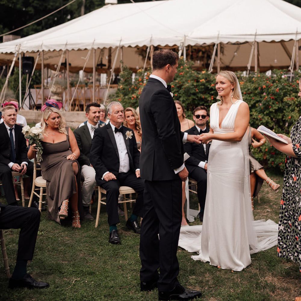 The bride and groom look into each other's eyes for their outdoor wedding ceremony 