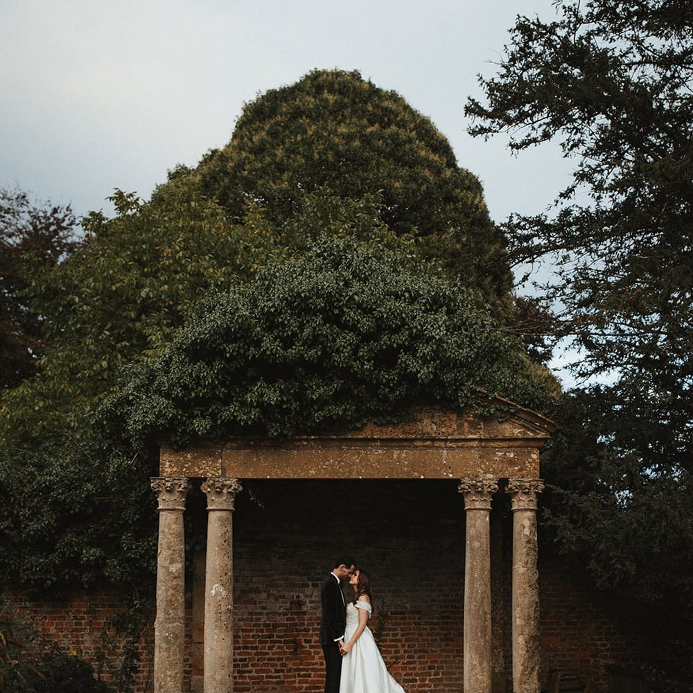 Groom in traditional black tie with the bride in a Pronovias wedding dress for Brympton House wedding venue 