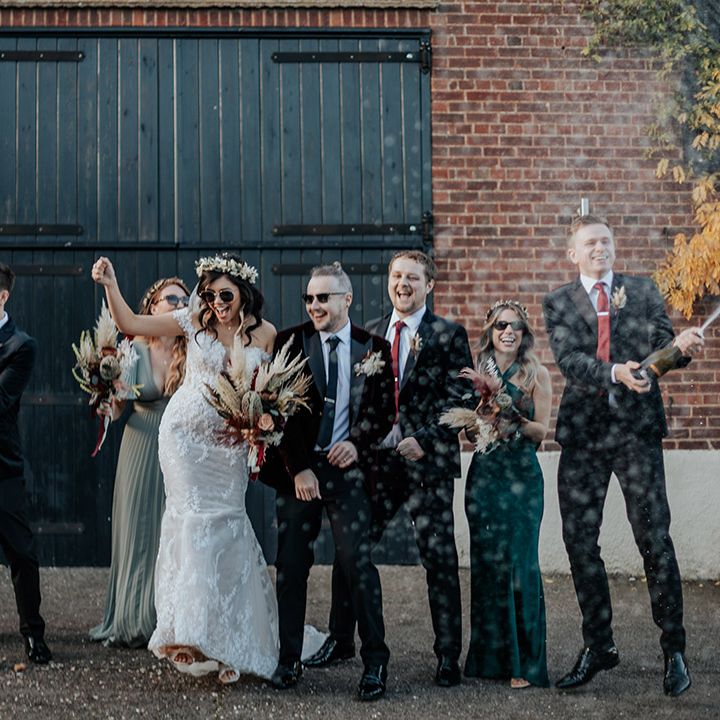 The groomsmen pop some Prosecco as the wedding party pose with sunglasses and other fun wedding accessories 
