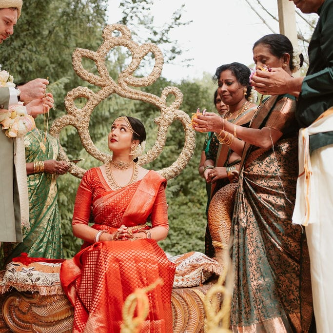 Hindu marriage ceremony under a mandal with bride in a red lehenga 