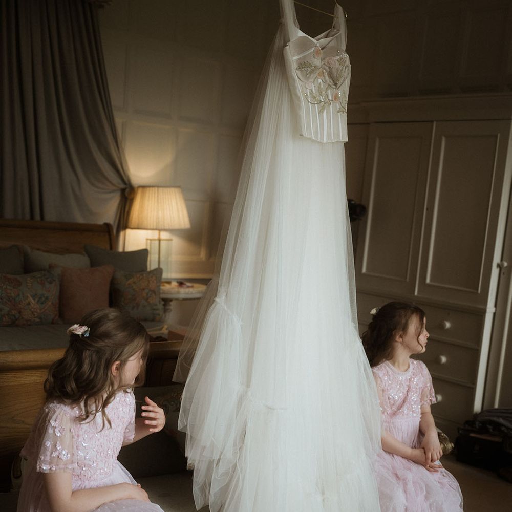 Bride's custom Bowen Dryden wedding dress with the two flower girls in pretty pink dresses 