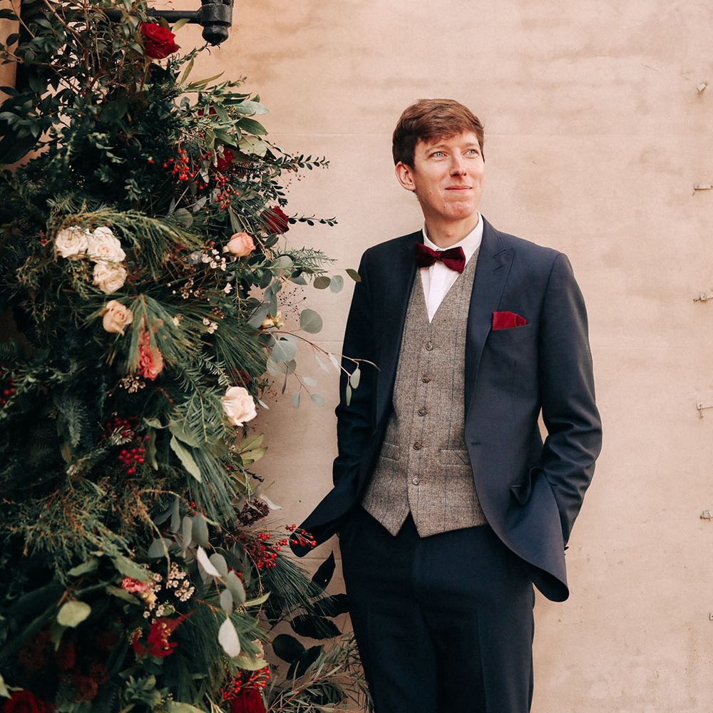 Winter wedding in December with groom wearing a navy suit and red bow tie 