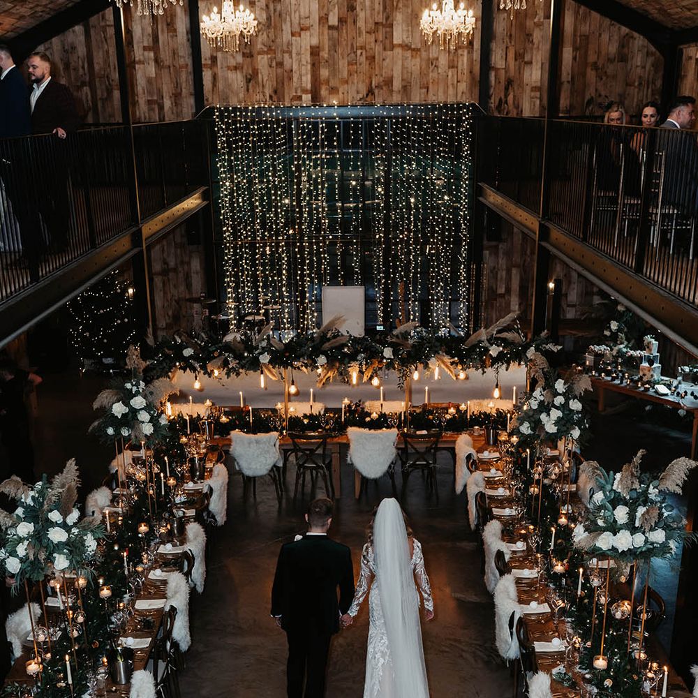 The bride and groom walk around Hidden River Cabins with long banquet tables and magical winter wedding decor 