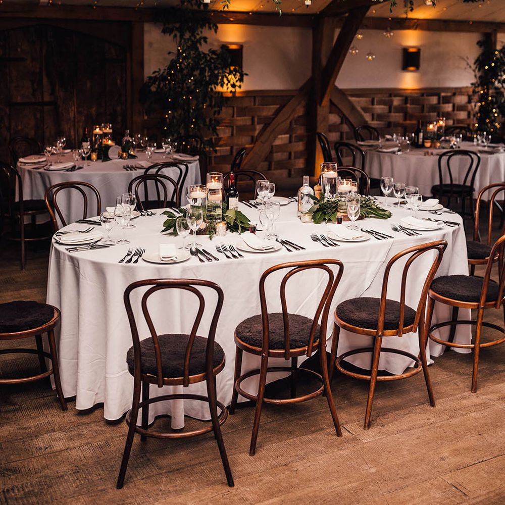 Winter wedding venue with table covered with a white table cloth with floating tea light table centrepieces 