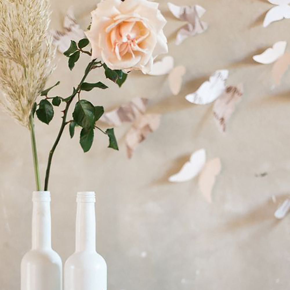 Butterfly wedding decor with flowers, glasses and 3d butterflies on the wall by Marion Heurteboust Photography