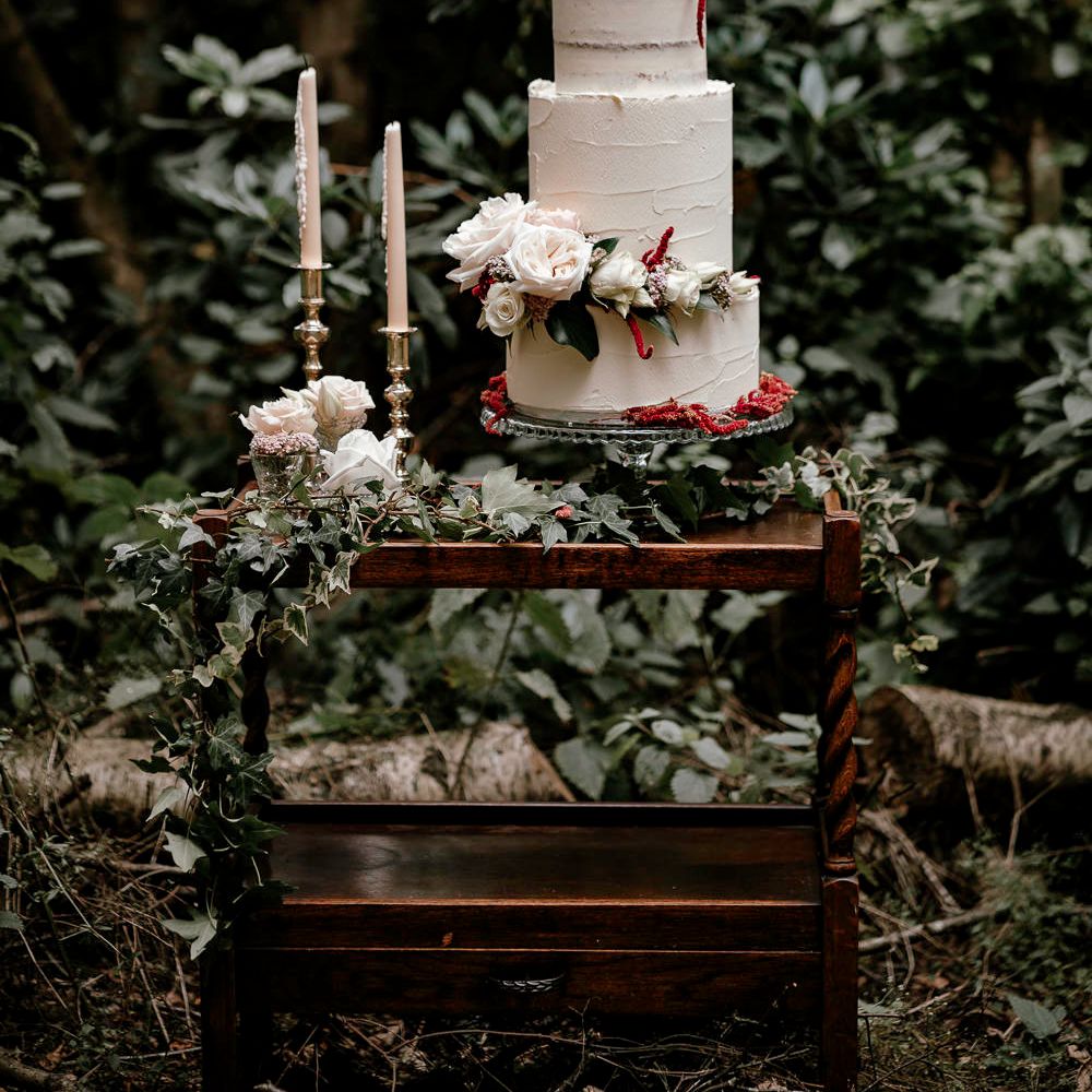 Semi naked wedding cake in vintage dresser at woodland wedding