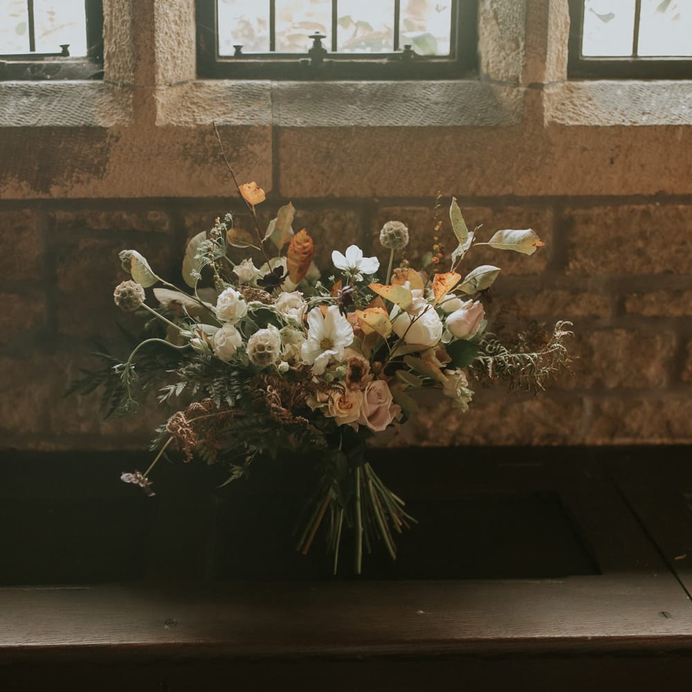 Autumn wedding bouquet with green, white and brown wedding flowers and foliage 