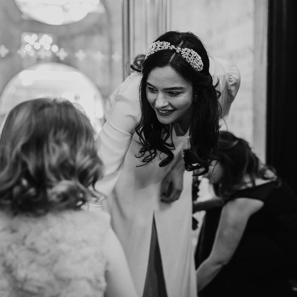 Black and white wedding photography action shot of bride helping flower girl