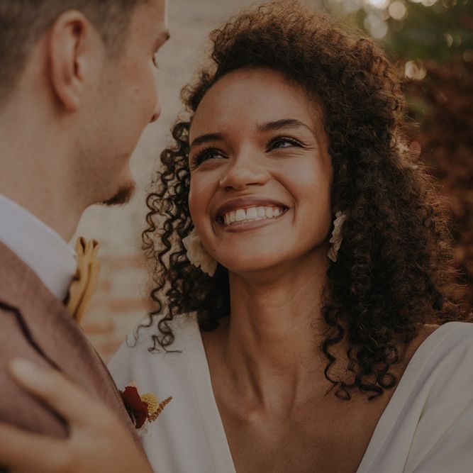 Beautiful black bride smiling with natural makeup up and curly hair 