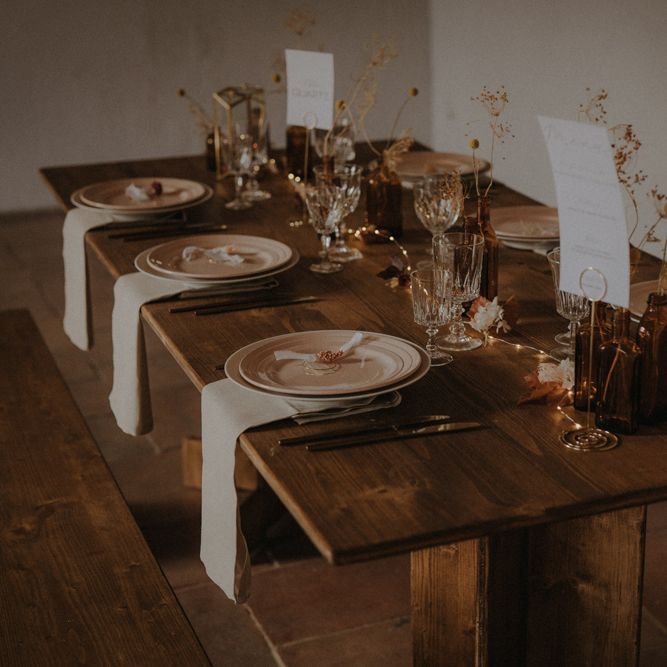 minimalist table decor with coloured plates, and dried grasses in vases as centrepiece decor 
