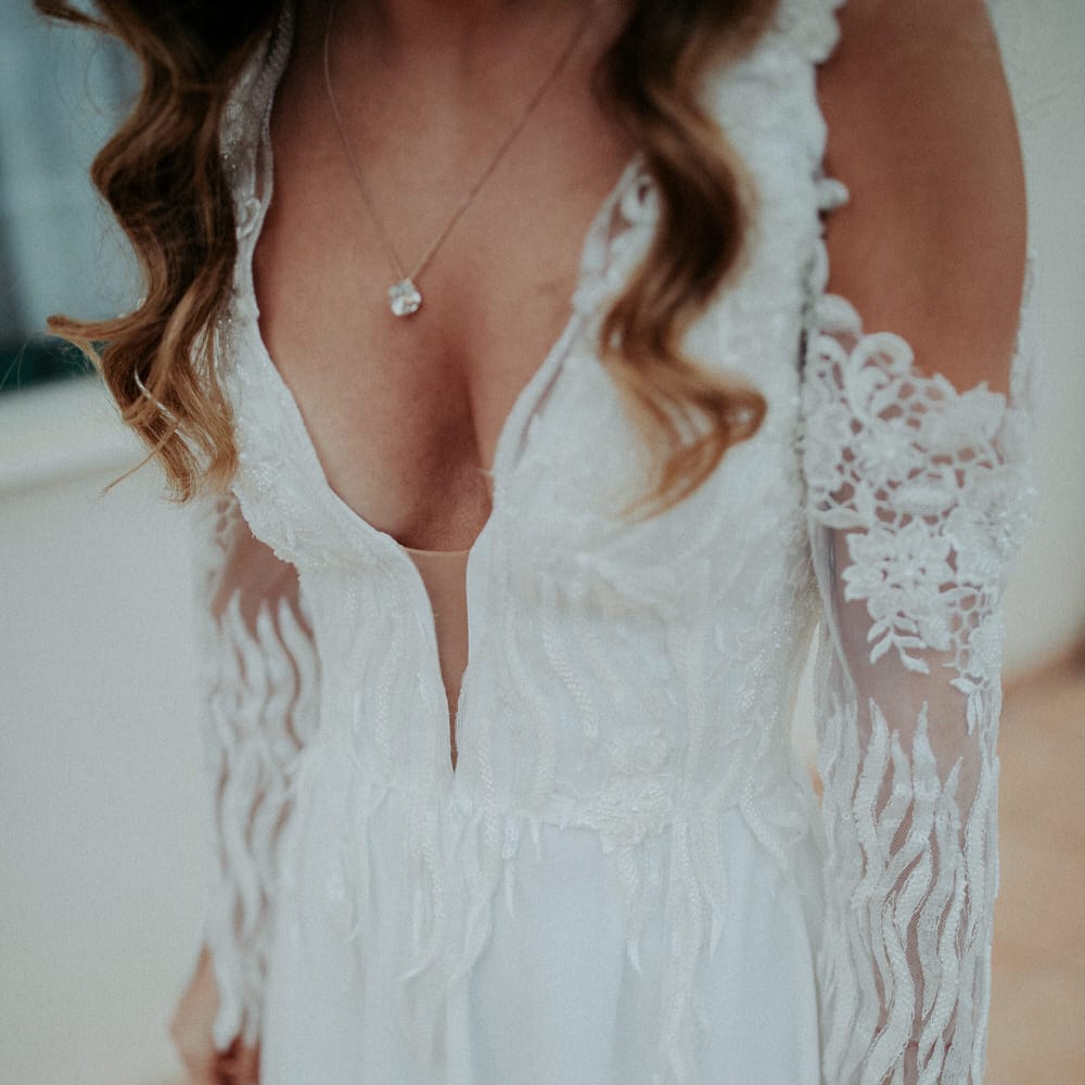 The bride wore a cold shoulder long sleeve Nadia Rapti wedding dress with plunge neckline and sequin embellishments