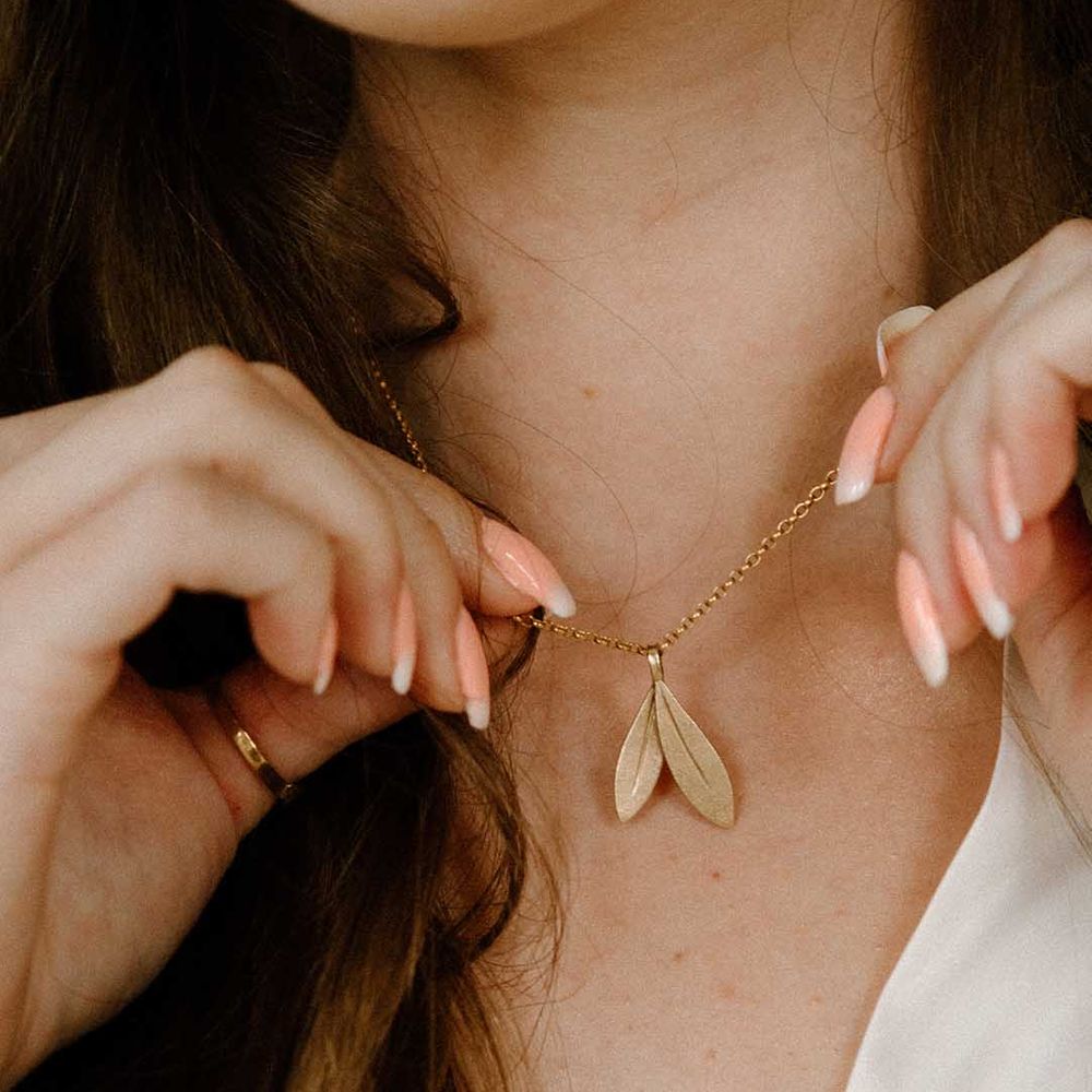 Bride with french manicured nails holding her custom necklace from recycled gold by Elizabeth Terzza Jewellery