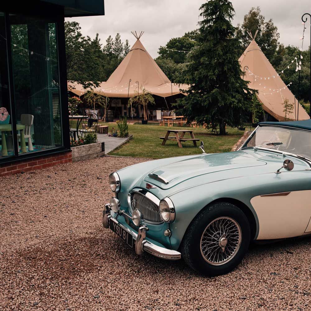 Blue and white vintage wedding car with soft top for tipi wedding reception