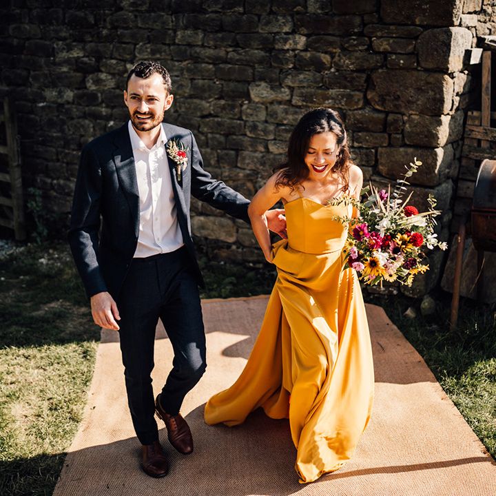 Bride & groom walk together outdoors