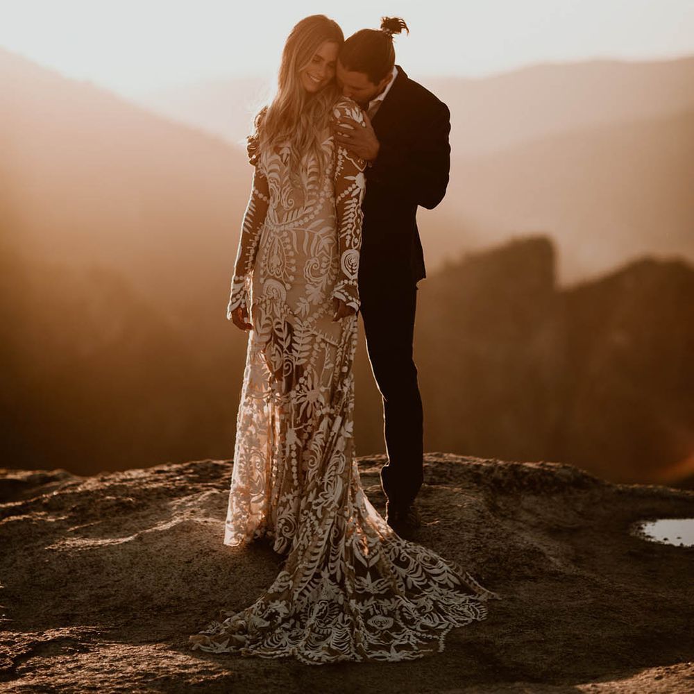 Bride & groom embrace on mountain