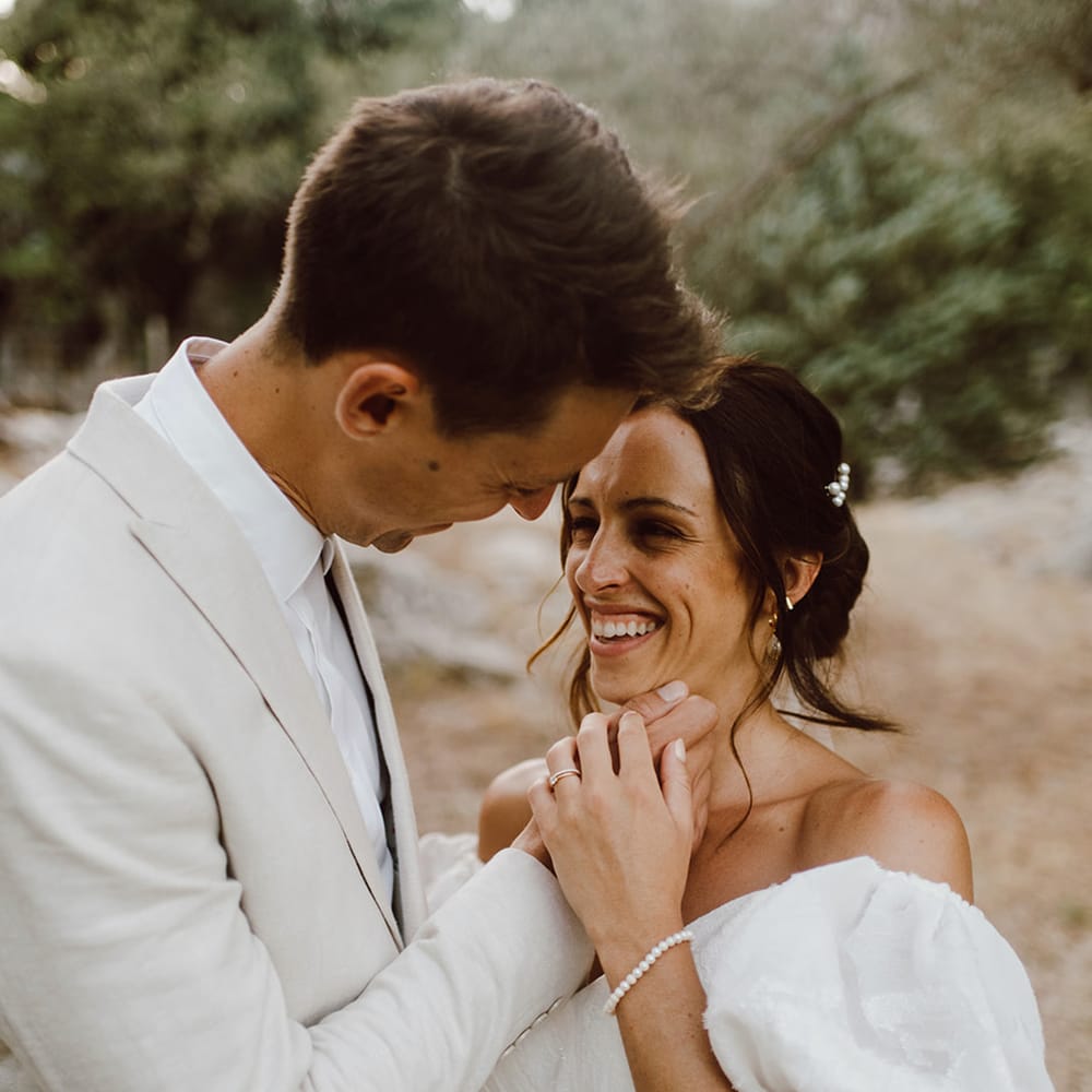 Bride and groom smile at each other 