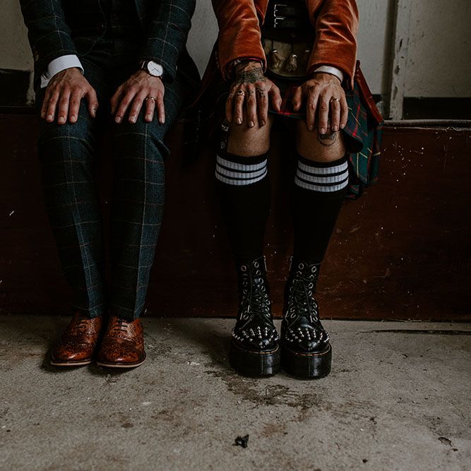 Groom wearing brogues next to his groom wearing platform studded Dr Martens and high socks