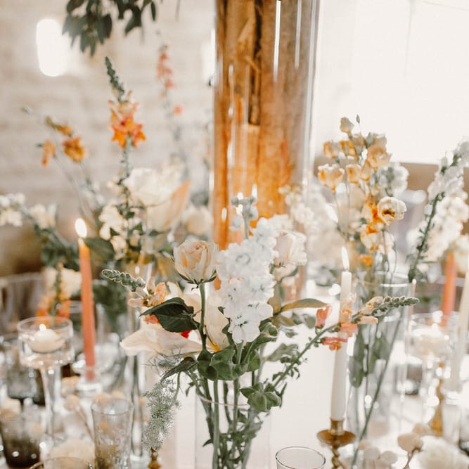 wedding table decor with coloured goblets and flower stems in vases 
