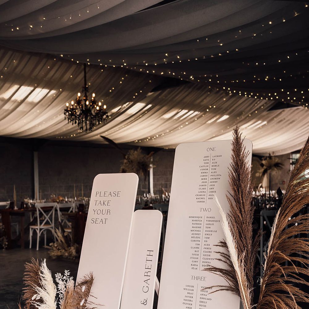 Large cream wedding table plan with pampas grass decor 