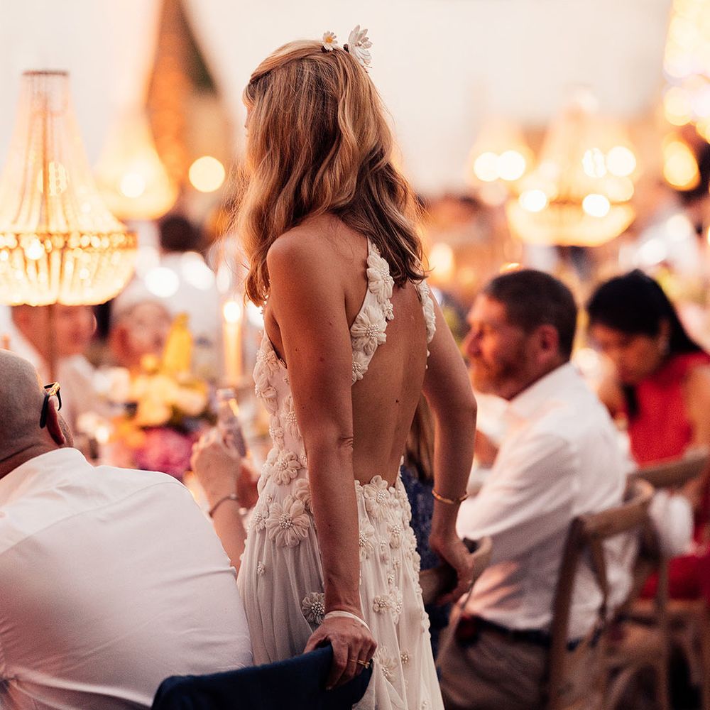 Bride wears flower hair accessories to match her flower halter neck style wedding dress