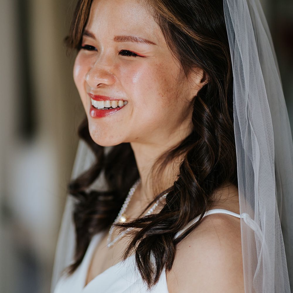 East Asian bride wears pale pink lipstick orange eyeliner 