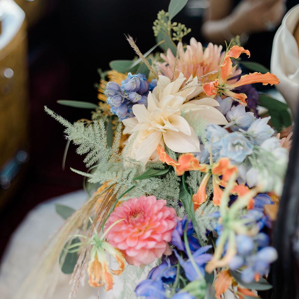 Colourful bridal bouquet finished with green foliage 