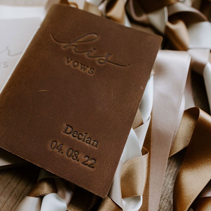 White and brown embossed his and hers wedding vow booklets for the bride and groom's bespoke and handfasting ceremony 
