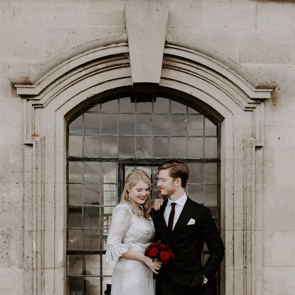 Gothic Halloween wedding with the bride in a metallic silver wedding dress with the groom in a black tie suit 