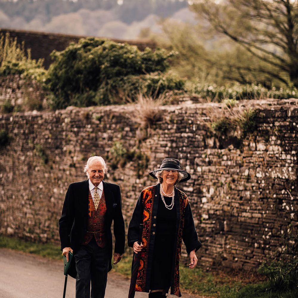The grandparents arriving at the wedding in matching orange wedding outfits 