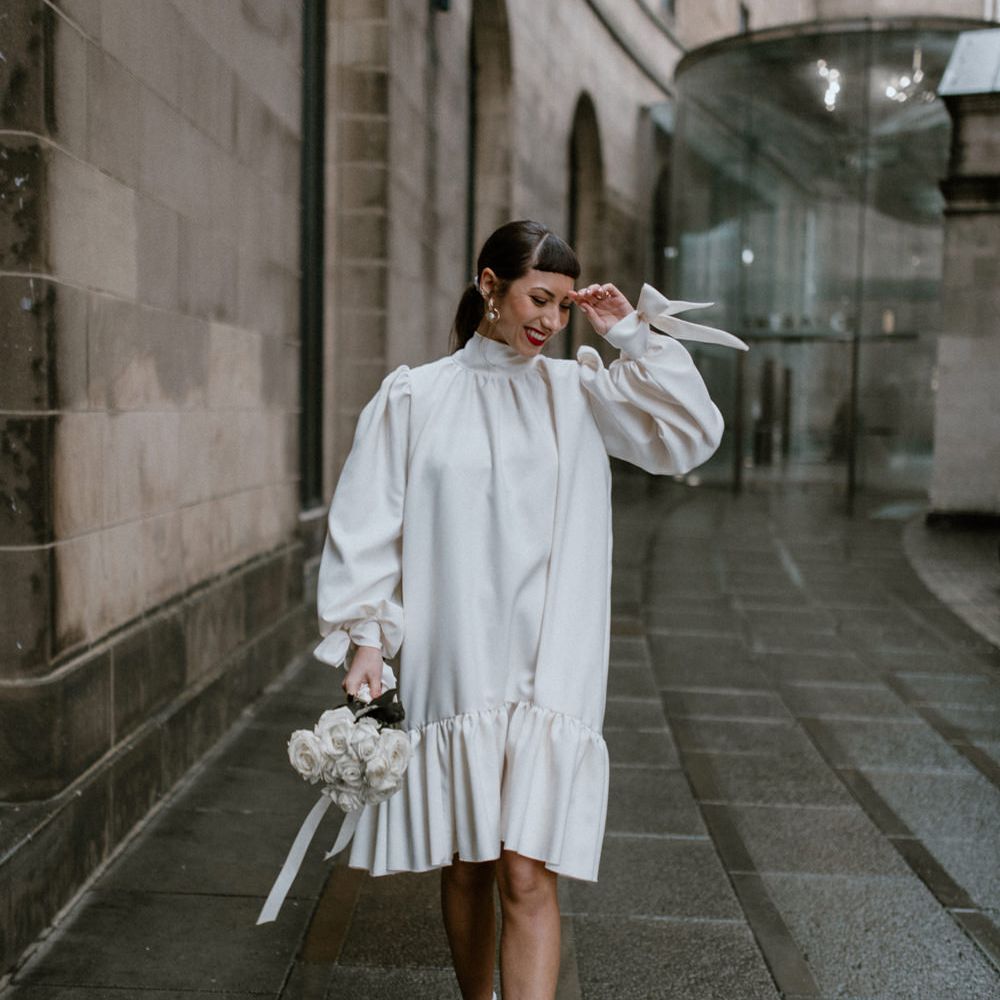 City bride in a knee length loose fitting wedding dress, socks and platform shoes 