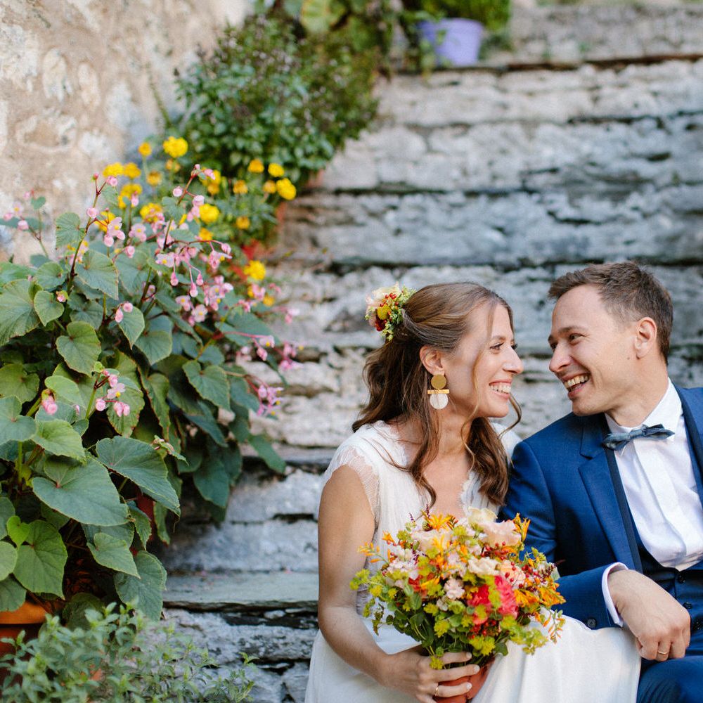 The bride and groom smiling on the steps of Valeni Boutique Hotel