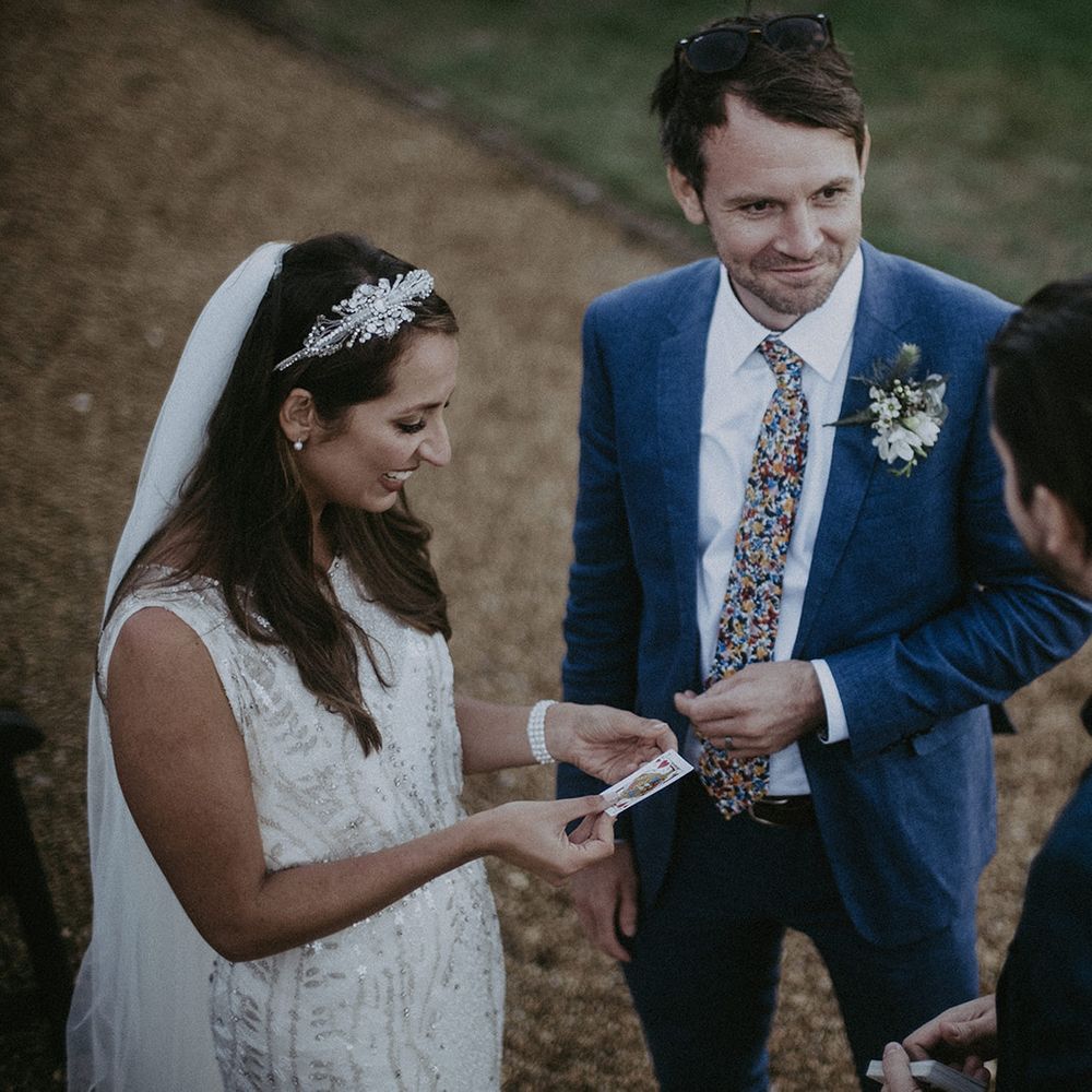 Bride & groom stand together speaking to wedding guests