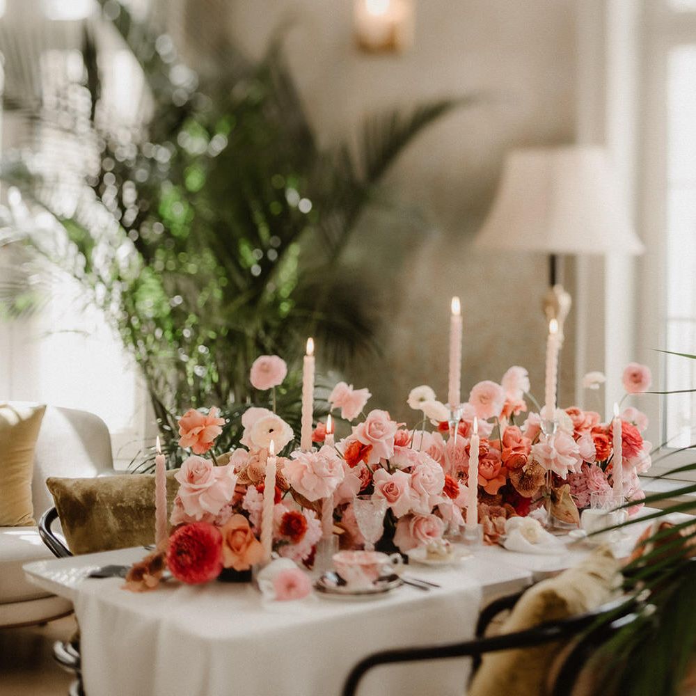 Luxe pink and peach wedding flowers tablescape at Amadria Park Hotel, with tapered candles and palm trees